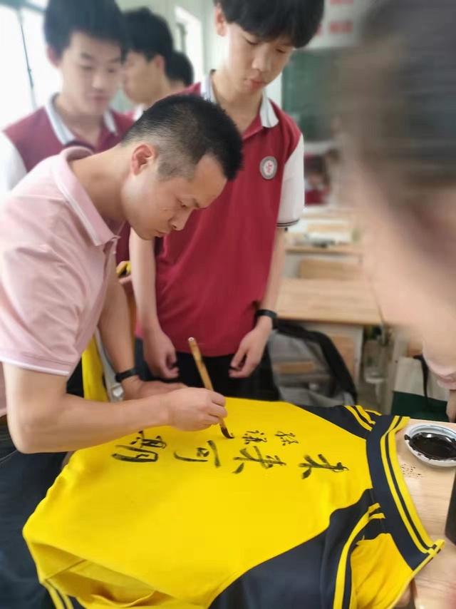 考生抱着校服“求祝福”，书法老师在校服上题字缩略图中国题字网
